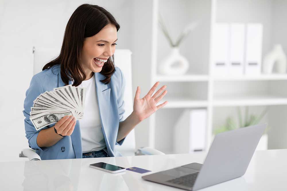 Excited woman holding cash